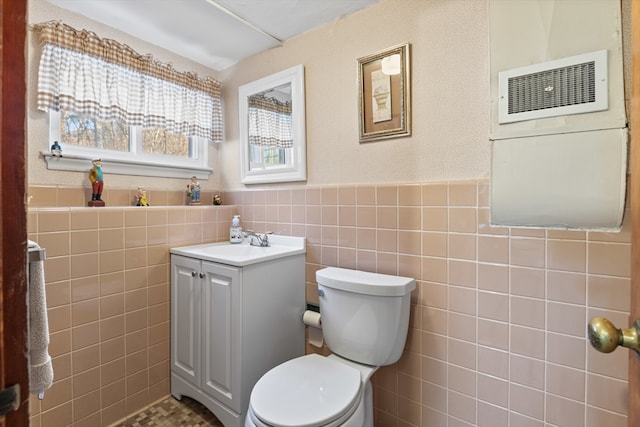 bathroom featuring tile walls, vanity, and toilet