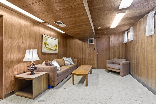 living room featuring wood ceiling and wooden walls