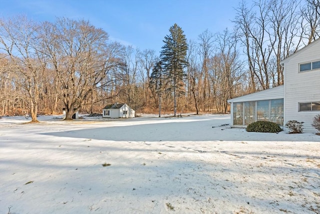 yard layered in snow with a sunroom