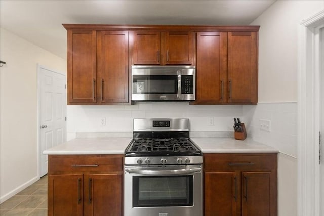 14 Carlson Cv, Weymouth, MA 02189 - kitchen featuring appliances with stainless steel finishes, light countertops, tasteful backsplash, and baseboards