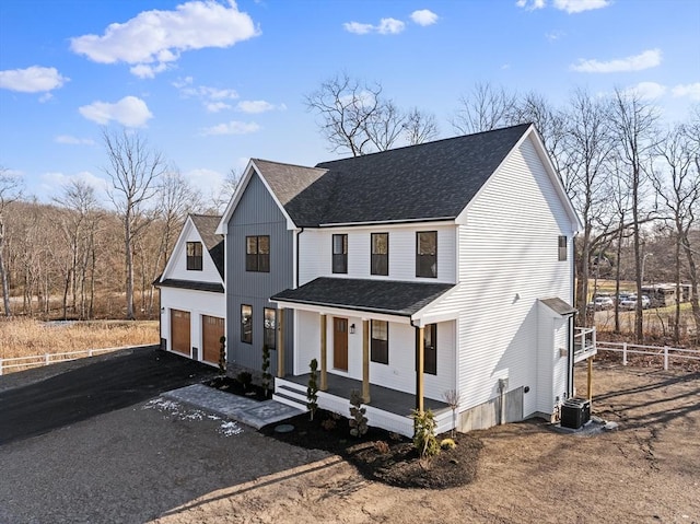 modern inspired farmhouse featuring covered porch, a garage, and central AC