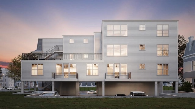 back of property at dusk with stairway and a balcony