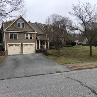 view of front of home with driveway, a front lawn, and a garage