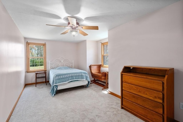 carpeted bedroom featuring baseboards and ceiling fan