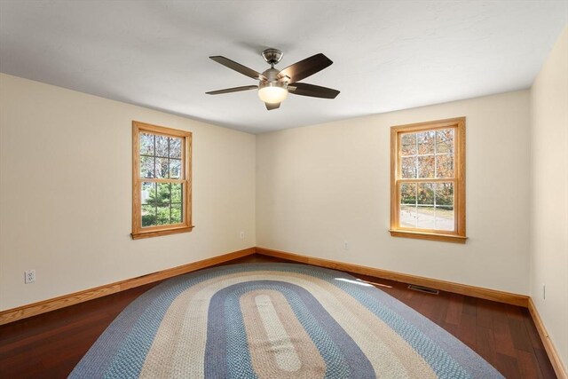 unfurnished room featuring baseboards, ceiling fan, wood finished floors, and visible vents
