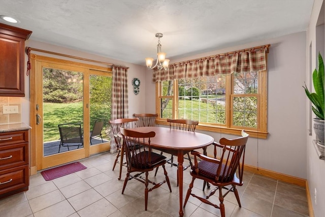 dining room with light tile patterned floors, baseboards, and a chandelier