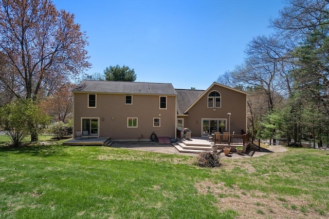 rear view of property featuring a lawn and a deck
