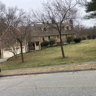 cape cod home featuring a front lawn and a chimney