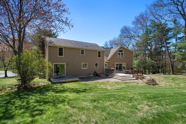 rear view of house featuring a lawn, a deck, and a chimney