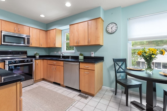 kitchen featuring appliances with stainless steel finishes, light tile patterned floors, and sink