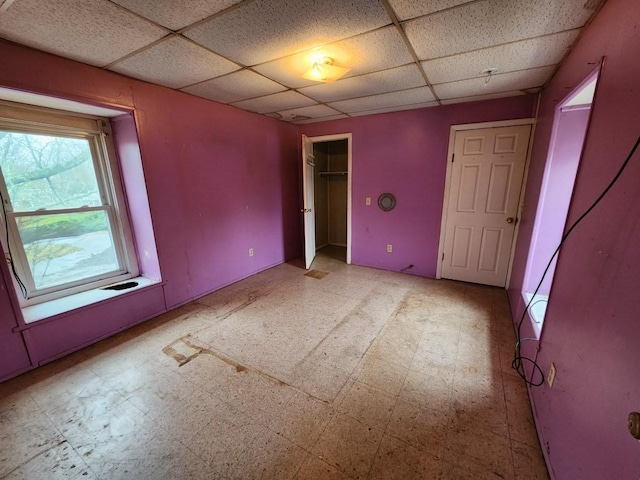 unfurnished bedroom featuring a paneled ceiling and a closet