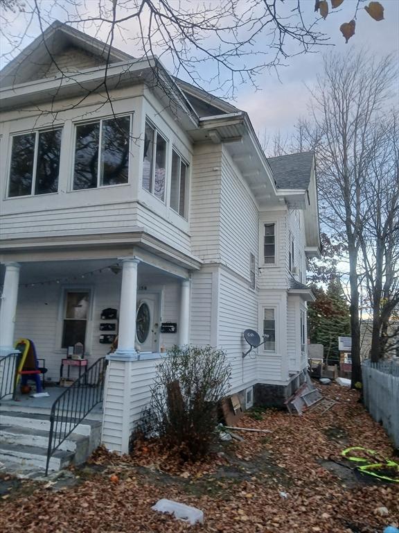 view of side of home featuring covered porch