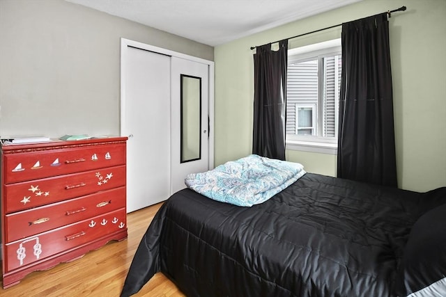 bedroom with light hardwood / wood-style flooring and a closet