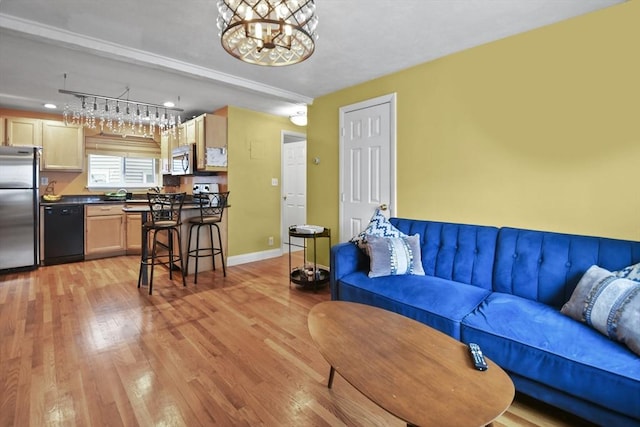 living room with light hardwood / wood-style floors and an inviting chandelier