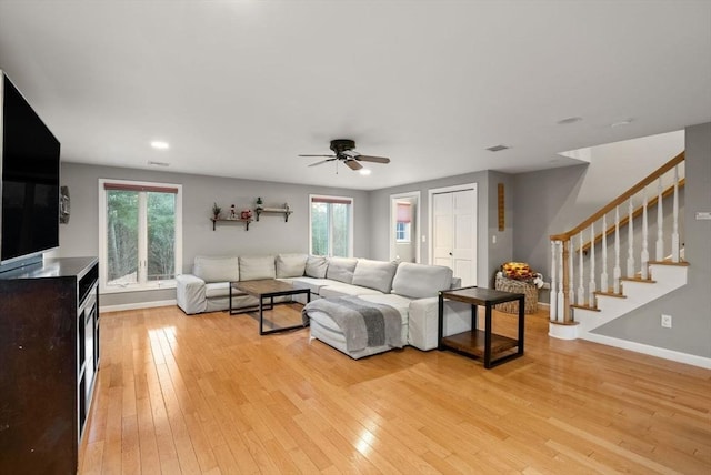 living room featuring light hardwood / wood-style flooring and ceiling fan