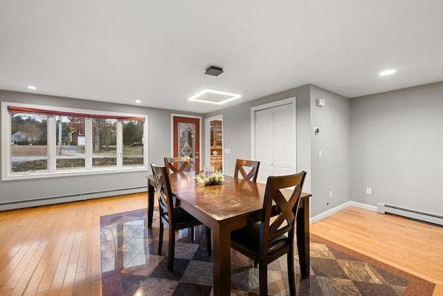 dining area with hardwood / wood-style flooring and a baseboard radiator