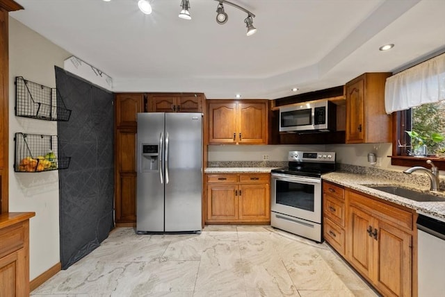 kitchen featuring light stone countertops, sink, and appliances with stainless steel finishes