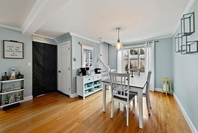 dining room with light hardwood / wood-style flooring and crown molding