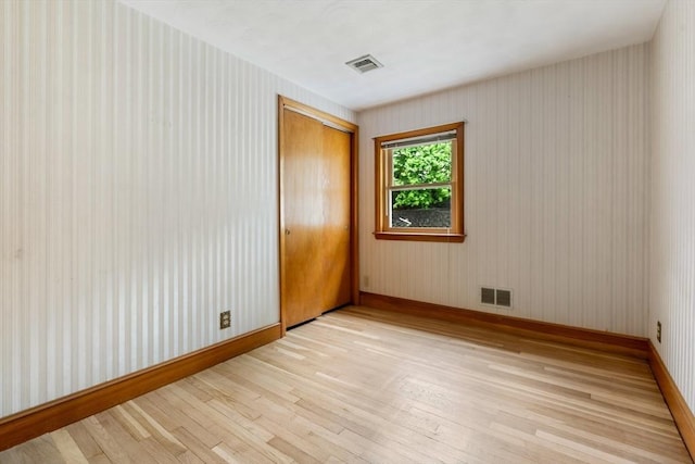 unfurnished room with light wood finished floors and baseboards