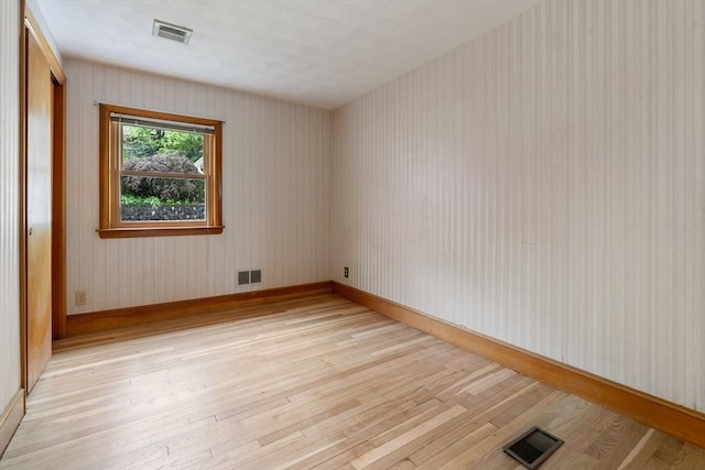 unfurnished room with light wood-style flooring and baseboards