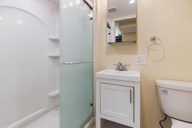 bathroom featuring a shower stall, vanity, and toilet