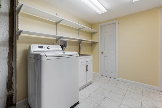 laundry room featuring washer / dryer, cabinet space, light marble finish floors, and baseboards