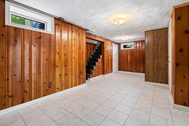 empty room featuring wood walls and stairway