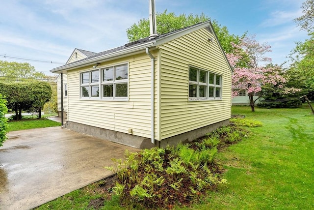 view of home's exterior with a patio area and a lawn