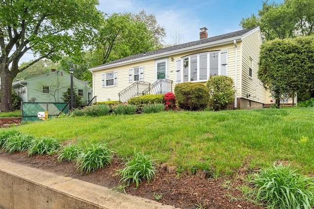 view of front of house featuring a chimney and fence