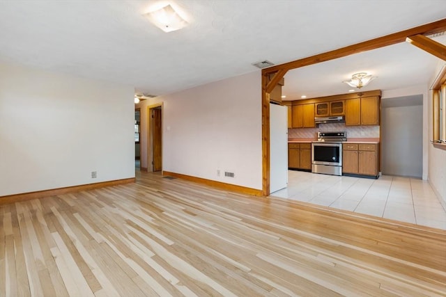unfurnished living room with baseboards and light wood-type flooring