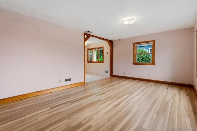 spare room featuring light wood-type flooring and baseboards