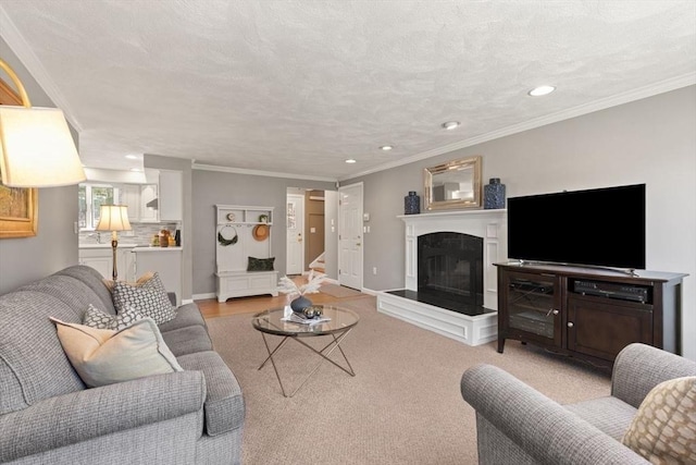 living area featuring recessed lighting, crown molding, baseboards, and a glass covered fireplace