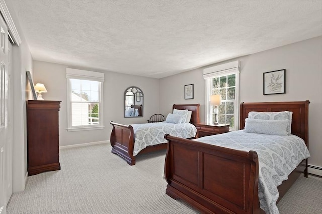 bedroom featuring baseboards, multiple windows, a textured ceiling, and light colored carpet