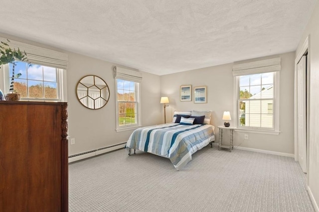 bedroom featuring carpet, baseboard heating, and multiple windows