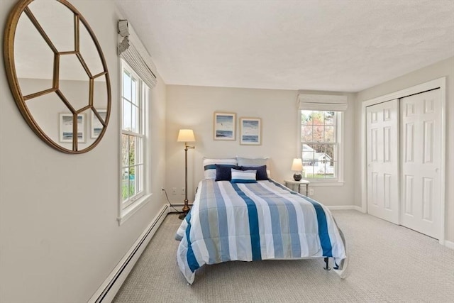 bedroom with carpet floors, baseboards, baseboard heating, and a closet