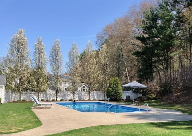 view of swimming pool featuring fence, a fenced in pool, a yard, and a patio area