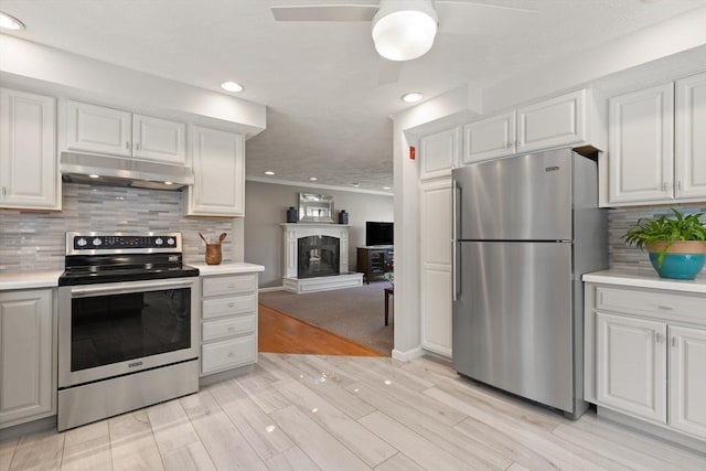 kitchen with under cabinet range hood, a ceiling fan, appliances with stainless steel finishes, and light countertops