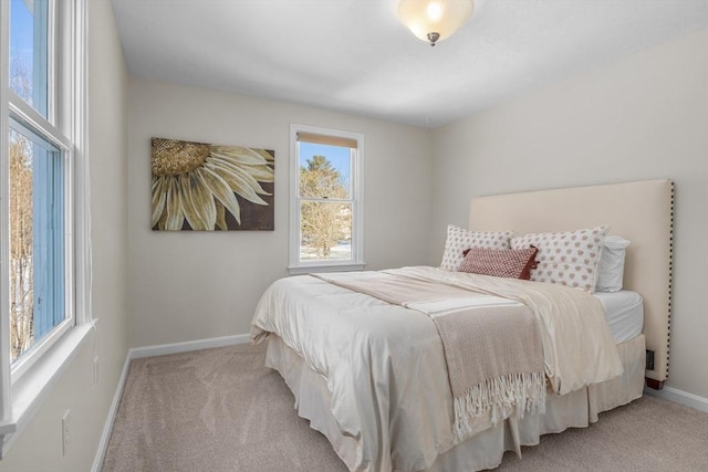 bedroom with light carpet and baseboards