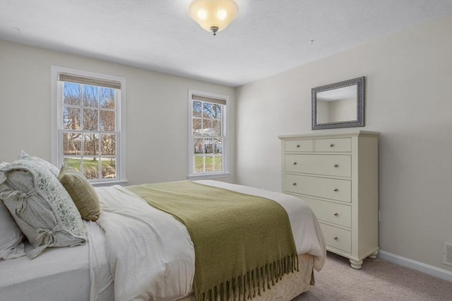 bedroom with visible vents, baseboards, and light colored carpet