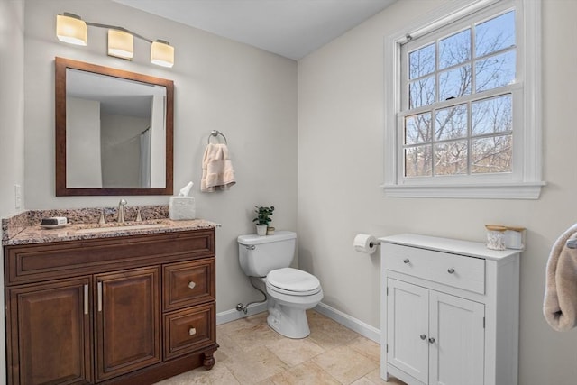 bathroom featuring baseboards, vanity, and toilet