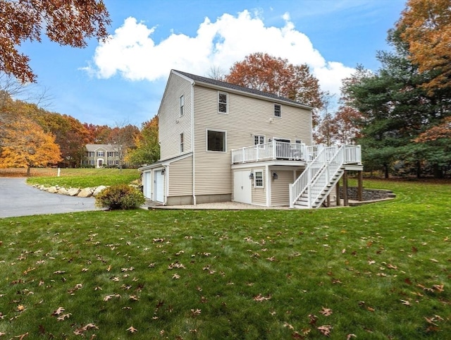 rear view of house with stairway, a deck, and a yard