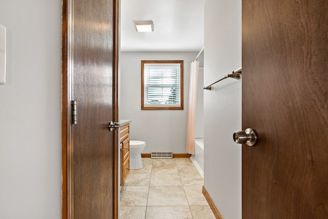 bathroom with shower / tub combo, tile patterned flooring, and toilet