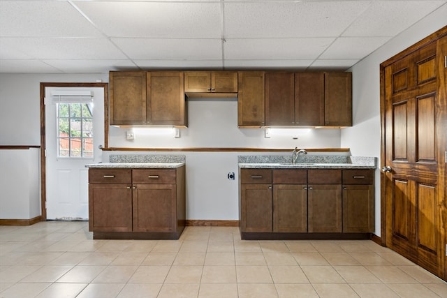 kitchen featuring a paneled ceiling and light tile patterned flooring