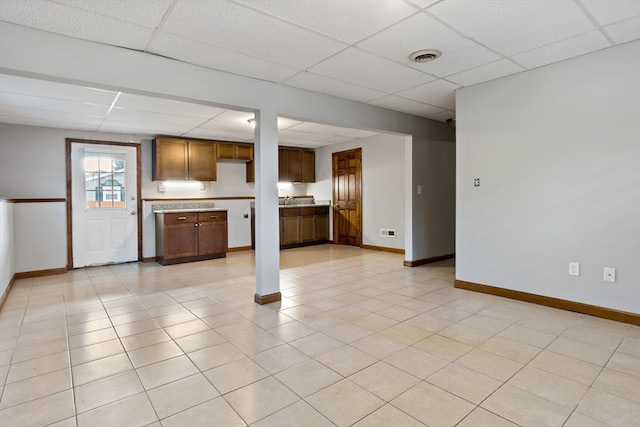 kitchen with sink, a drop ceiling, and light tile patterned floors