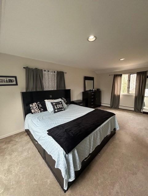 bedroom featuring a baseboard heating unit, recessed lighting, light colored carpet, and baseboards