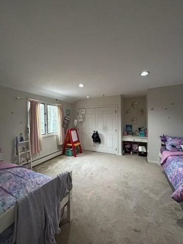 carpeted bedroom featuring baseboard heating and recessed lighting