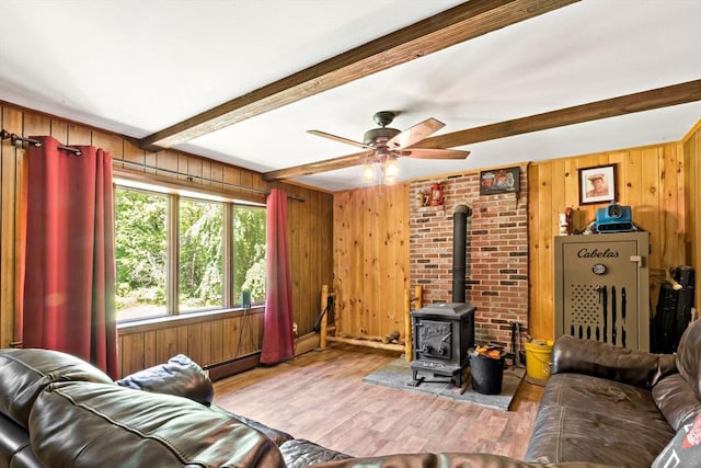 92 Rocky Hill Rd, Rehoboth, MA 02769 - living room with beam ceiling, wooden walls, a wood stove, wood finished floors, and ceiling fan