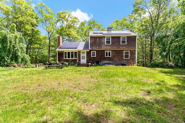 92 Rocky Hill Rd, Rehoboth, MA 02769 - rear view of house featuring entry steps, a chimney, solar panels, and a lawn