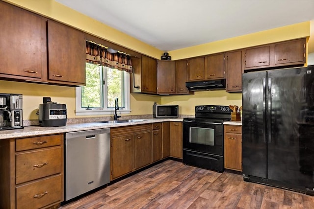 92 Rocky Hill Rd, Rehoboth, MA 02769 - kitchen with black appliances, under cabinet range hood, a sink, light countertops, and dark wood-type flooring