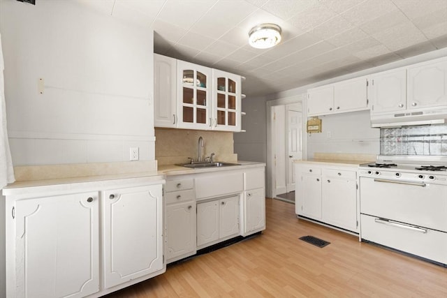 12 Porter St, Everett, MA 02149 - kitchen with white stove, under cabinet range hood, white cabinetry, light wood finished floors, and glass insert cabinets